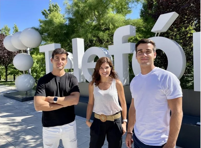 Alberto, Marta Antúnez of Wayra Barcelona and Alejandro in front of the giant Telefónica sign