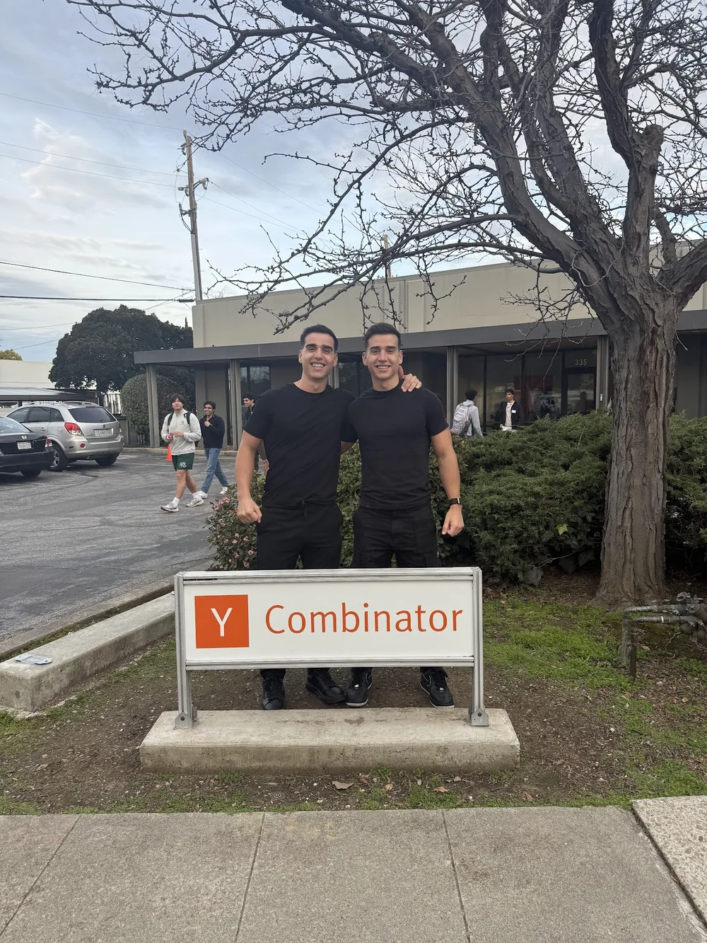 Alejandro and Alberto standing behind the Y Combinator sign