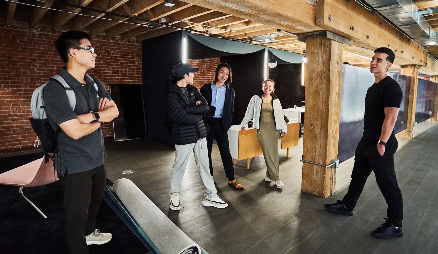 The Didit team walking through the brick and timber San Francisco office