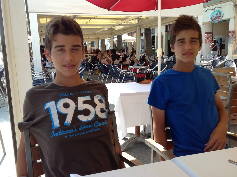 Alejandro and Alberto as teenagers at a restaurant terrace
